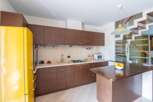 a kitchen with wooden cabinets and a yellow refrigerator at WANDERLUST HOTEL - SUITE & SPA - APARTMENTS & VILLAS - Bardolino, Lago di Garda - Verona in Bardolino