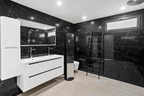 La salle de bains noire est pourvue d'un lavabo et d'une douche. dans l'établissement Havre de Paix avec Villa Prestige Cannes Luxe, Piscine Chauffée, Alarme, Caméras Parking privée, au Cannet
