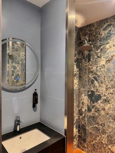 a bathroom with a sink and a shower at Nebula Hotel by Ine's in Assendelft