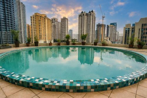 a large swimming pool in a city with tall buildings at Elegant 2BR Manila Bay Sunset near US Embassy in Manila