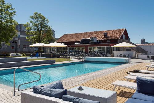 - une piscine avec des chaises longues dans l'établissement Scandic Visby, à Visby