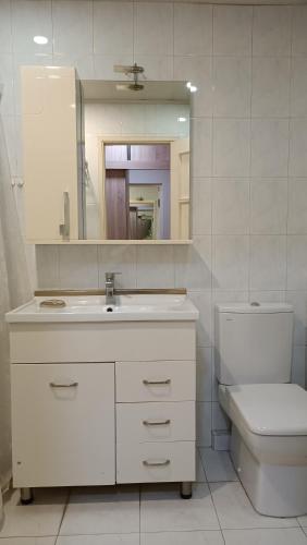 a bathroom with a sink and a toilet and a mirror at Orbeli Apartment in Aghk'ilisa