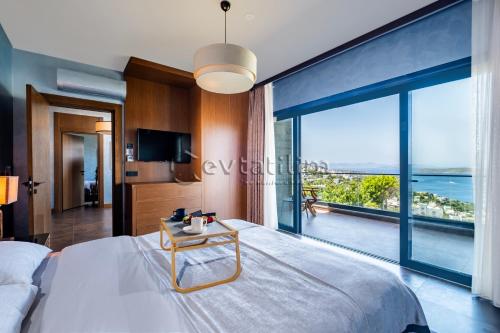 a bedroom with a large bed with a view of the ocean at Villa Sunset by EvTatilim Bodrum, Yalikavak in Bodrum City