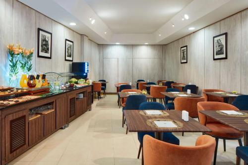 a restaurant with wooden walls and tables and chairs at NH Lisboa Campo Grande in Lisbon
