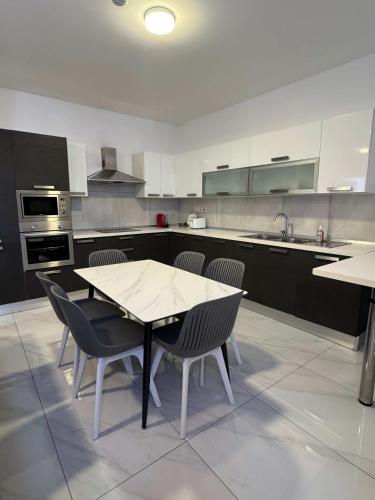 a kitchen with a table and chairs in it at 3 Bedrm Penthouse Amazing Views in St Paul's Bay