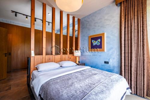 a bedroom with a large bed with blue walls at Villa Sunset by EvTatilim Bodrum, Yalikavak in Bodrum City