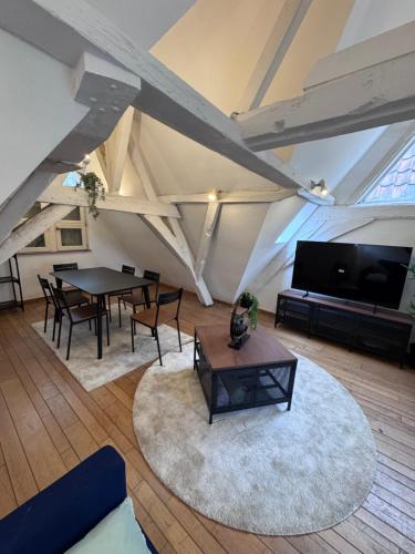 a living room with a table and chairs and a tv at Gent-cosy-stay in Ghent