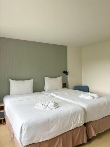 a large white bed with two towels on it at Phangan Utopia Resort in Mae Haad