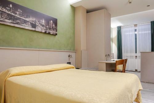 a bedroom with a large bed and a table at Hotel POSTA - 2 stars - Comfortable Stay in Ventimiglia in Ventimiglia