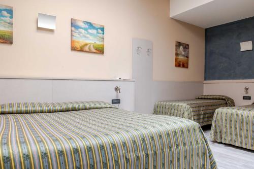 a hotel room with two beds and two chairs at Hotel POSTA - 2 stars - Comfortable Stay in Ventimiglia in Ventimiglia