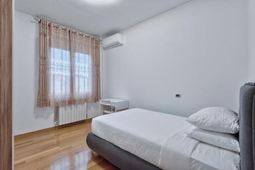 a white bedroom with a bed and a window at Paleocapa Apartments in Venice