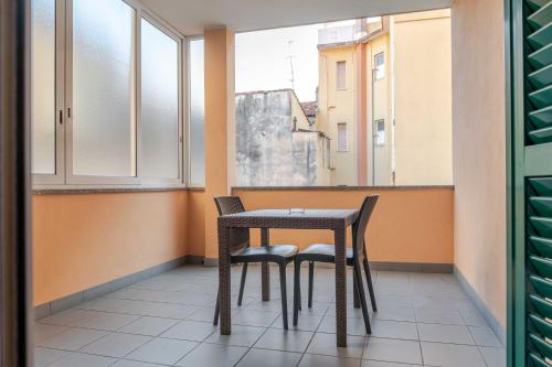 a table and two chairs in a room with windows at Hotel POSTA - 2 stars - Comfortable Stay in Ventimiglia in Ventimiglia