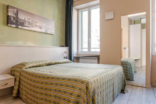 a bedroom with a bed with a blanket on it at Hotel POSTA - 2 stars - Comfortable Stay in Ventimiglia in Ventimiglia