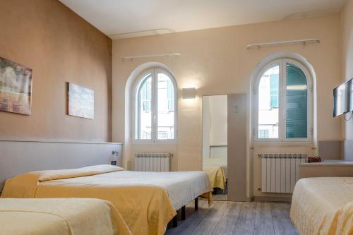a room with two beds and two windows at Hotel POSTA - 2 stars - Comfortable Stay in Ventimiglia in Ventimiglia