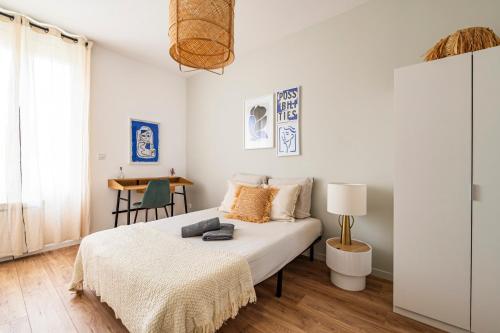 une chambre avec un lit et une table avec une chaise dans l'établissement Maison du Barbâtre - 4 chambres chaleureuses, à Reims