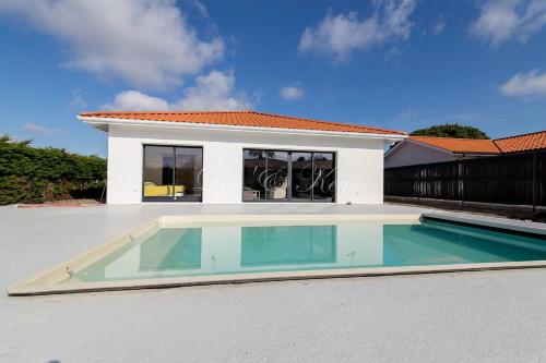 une piscine devant une maison dans l'établissement Bisca jolie maison-piscine, à Biscarrosse