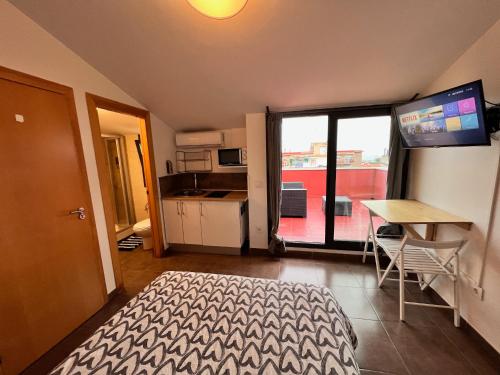 a bedroom with a bed and a table and a kitchen at MT Boutique Suites y Apartamentos - Adults Only - in Mataró