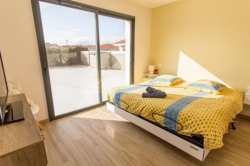 une chambre avec un lit et une grande fenêtre dans l'établissement Bisca jolie maison-piscine, à Biscarrosse