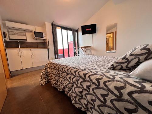 a bedroom with a bed with a black and white comforter at MT Boutique Suites y Apartamentos - Adults Only - in Mataró