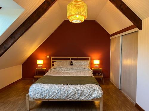 a bedroom with a large bed with two lamps at Ty roparzh in Le Haut-Corlay