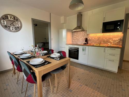a kitchen with a wooden table and chairs in a room at Ty roparzh in Le Haut-Corlay