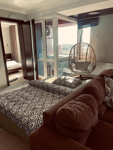 a living room with a couch and a large window at Panoramic city center apartment in Klaipėda