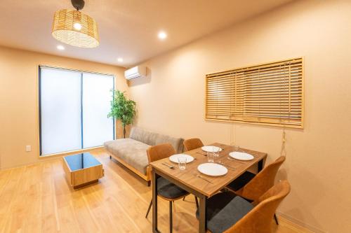 a living room with a table and a couch at Shinimamiya Ebisu 戎 in Osaka