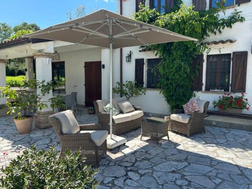 a group of chairs and an umbrella on a patio at Casa Sant Angelo in Pesaro