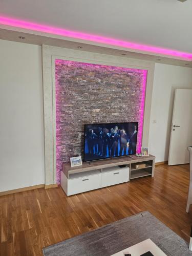 a living room with a tv and a brick wall at Apartmani Venera in Belgrade