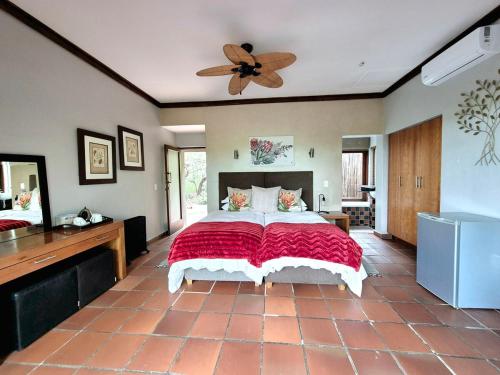 a bedroom with a large bed and a ceiling fan at Lovely family home in the bush in Warmbaths