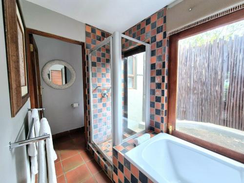 a bathroom with a large tub and a window at Lovely family home in the bush in Warmbaths