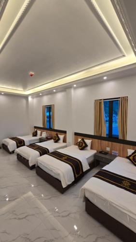 a group of four beds in a room at New Highland Hotel Yen Bai in Kim Nội