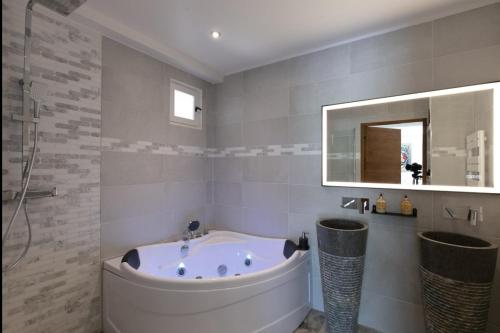 ein Badezimmer mit Badewanne und Spiegel in der Unterkunft Bastide Blanche in Les Arcs sur Argens