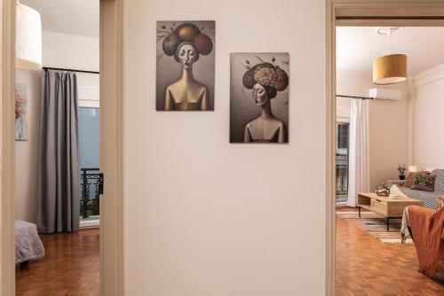 a living room with three paintings on the wall at Aegealis Stay in Samos