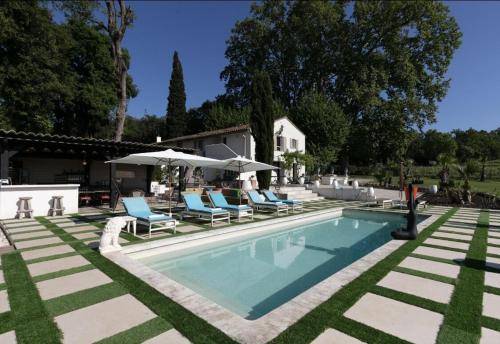 une piscine avec des chaises bleues et des parasols dans l'établissement Grand T2 Domaine de prestige au cœur des Vignes, aux Arcs-sur-Argens