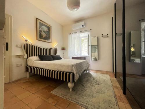 a bedroom with a bed with a striped headboard and a window at Amiata Escape in Arcidosso