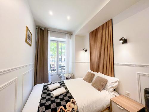 une petite chambre avec un lit et une fenêtre dans l'établissement 81 - Paris Luxe Sebastopol, à Paris