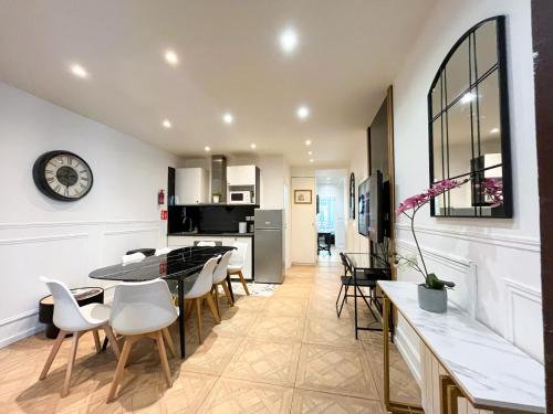 une cuisine et une salle à manger avec une table et des chaises dans l'établissement 81 - Paris Luxe Sebastopol, à Paris