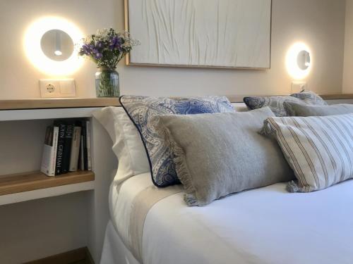 a bed with pillows and a vase of flowers on it at Casa del concejo segovia in Segovia