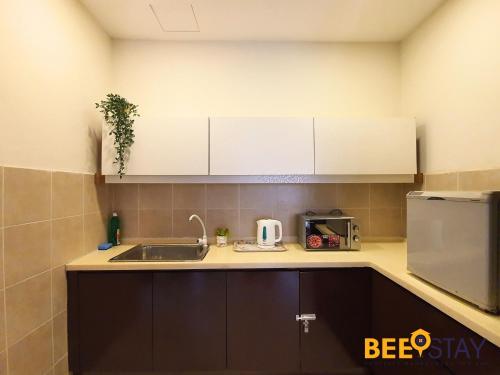 a small kitchen with a sink and a microwave at Gold Coast Morib Studio l Apartment I Penthouse in Banting