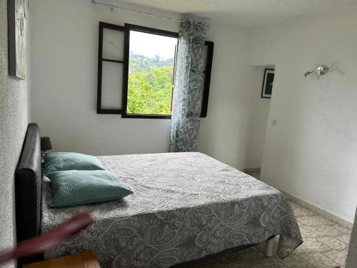 a bedroom with a bed and a window at Appartement convivial à Marignana, proche de la nature in Marignana
