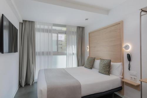 a bedroom with a large white bed and a window at Casa Lit Barcelona in Barcelona