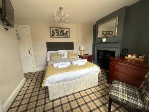 a bedroom with a large bed and a fireplace at Cookson Room in Haydon Bridge