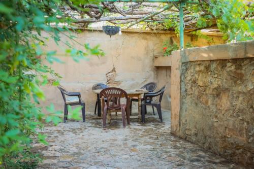 a table and chairs sitting next to a wall at Auberge Souktana in Taliouine
