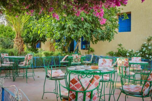 a group of tables and chairs with pink flowers at Auberge Souktana in Taliouine