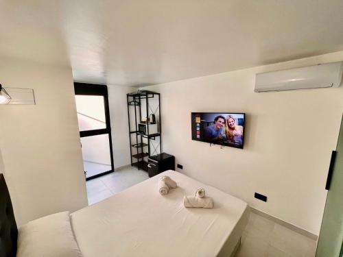 a white room with a tv on the wall at MT Boutique Suites y Apartamentos - Adults Only - in Mataró