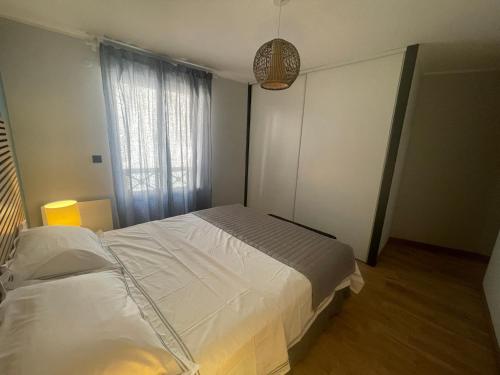 a bedroom with a large bed and a window at Les Colonnes d'Andrea in Nevers