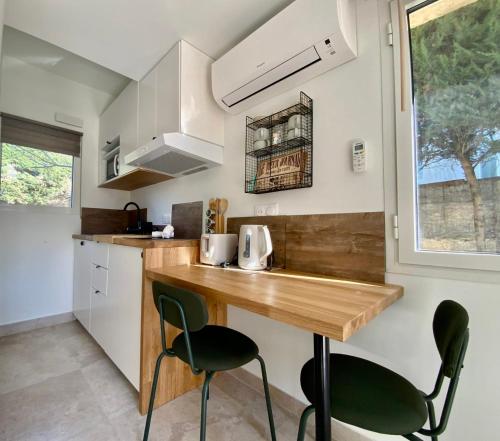 - une cuisine avec un comptoir en bois et 2 chaises dans l'établissement Le Maguelone- Studio with beach access air conditioning and exterior !, à Palavas-les-Flots