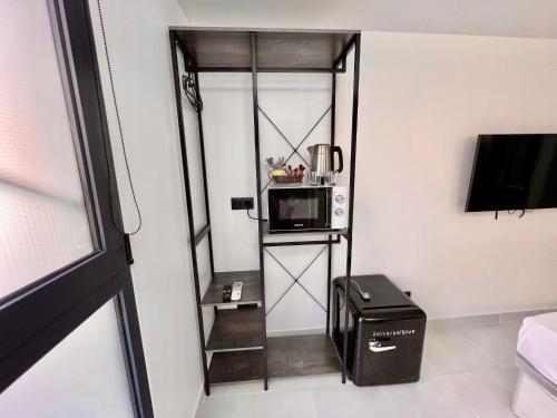 a small room with a microwave and a shelf with a microwave at MT Boutique Suites y Apartamentos - Adults Only - in Mataró