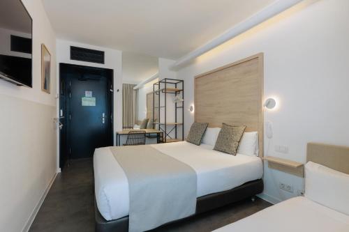 a bedroom with a large white bed and a desk at Casa Lit Barcelona in Barcelona